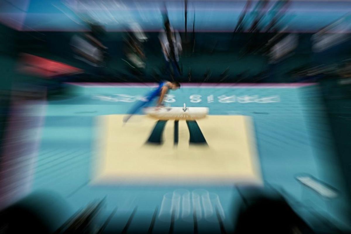This zooming effet photograph shows an athlete practising in the artistic gymnastics men's pommel horse final during the Paris 2024 Olympic Games at the Bercy Arena in Paris, on August 3, 2024. Gabriel BOUYS / AFP