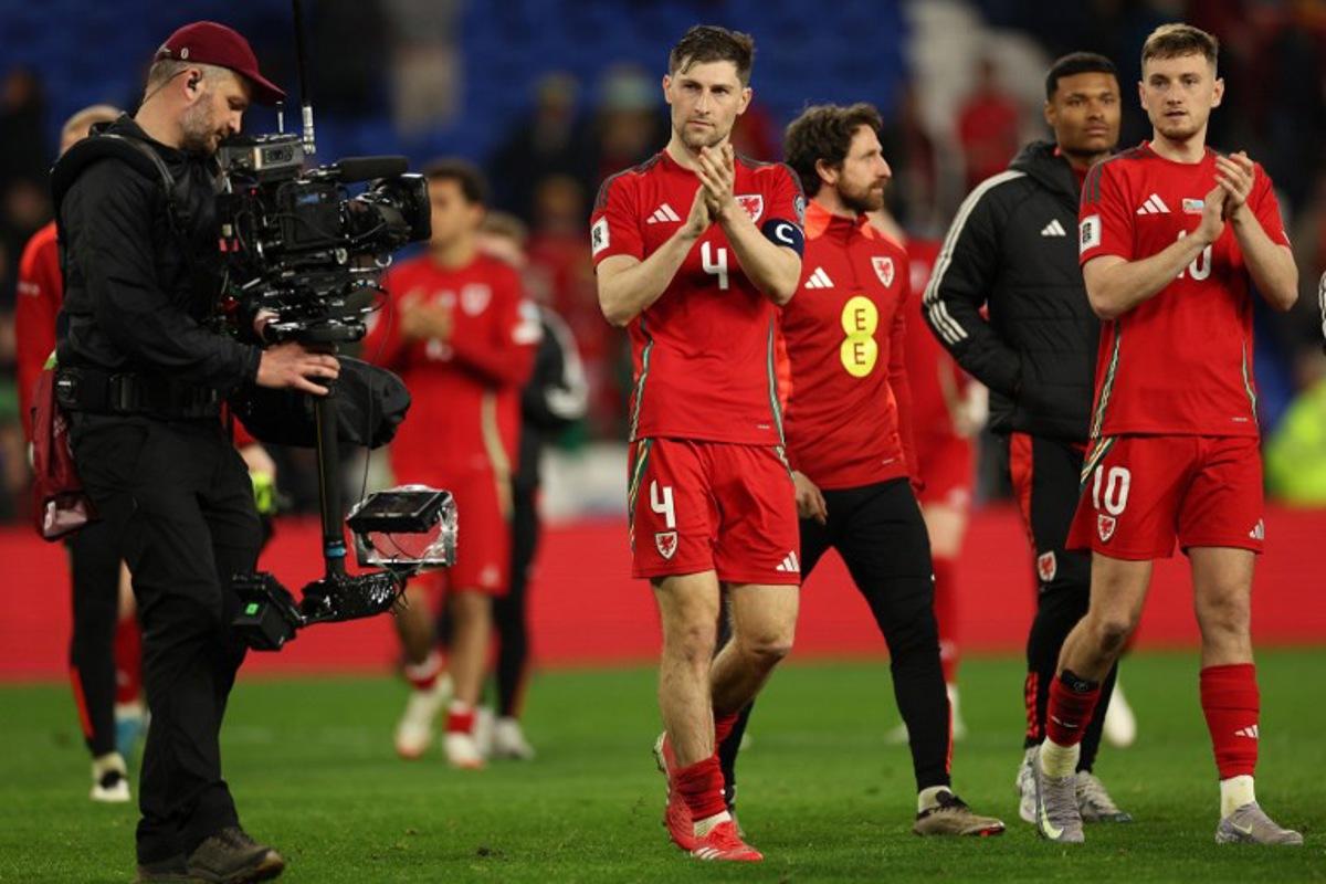 Wales' defender #04 Ben Davies (C) and Wales' midfielder #10 David Brooks (R) applaud the fans following during the 2026 World Cup Group J qualifier football match between Wales and Kazakhstan, at Cardiff City Stadium, in Cardiff, on March 22, 2025. Wales won the match 3-1. Adrian Dennis / AFP