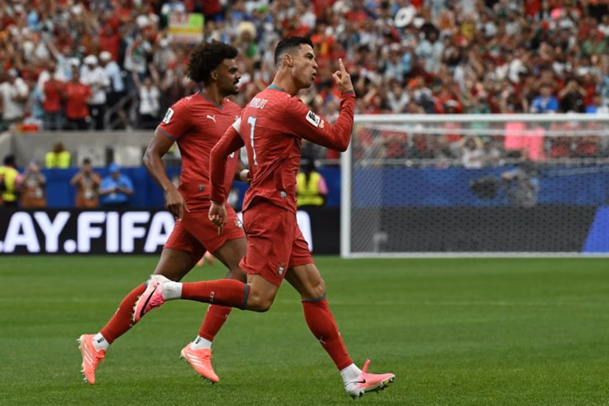 Portugal's forward #07 Cristiano Ronaldo (R) celebrates after scoring the opening goal during the 2026 World Cup Group K football match between Portugal and Uzbekistan at the Houston Stadium in Houston on June 23, 2026. RONALDO SCHEMIDT / AFP