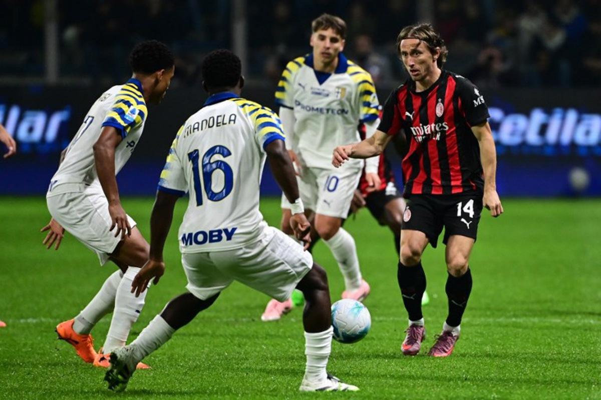 AC Milan's Croatian midfielder #14 Luka Modric (R) fights for the ball with Parma's Belgian midfielder #16 Mandela Keita (2nd L) during the Italian Serie A football match between Parma and AC Milan at the San Siro Stadium in Parma, northern Italy, on November 8, 2025. Piero CRUCIATTI / AFP