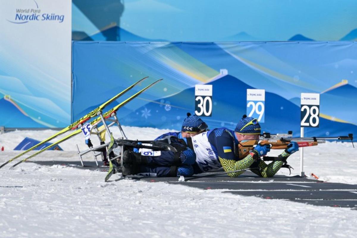 Ukraine's Maksym Yarovyi (R) and Pavlo Bal (L) compete in the men's middle distance sitting para biathlon final event on March 8, 2022 at the Zhangjiakou National Biathlon Centre, during the Beijing 2022 Winter Paralympic Games. Mohd Rasfan / AFP