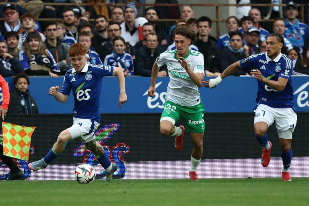 Saint Etienne's Belgian forward #32 Lucas Stassin fights for the ball with Strasbourg's Argentinian defender #32 Valentin Barco and Strasbourg's Portuguese forward #07 Diego Moreira during the French L1 football match between RC Strasbourg Alsace and AS Saint-Etienne at Stade de la Meinau in Strasbourg, north-eastern France on April 26, 2025. Frederick FLORIN / AFP