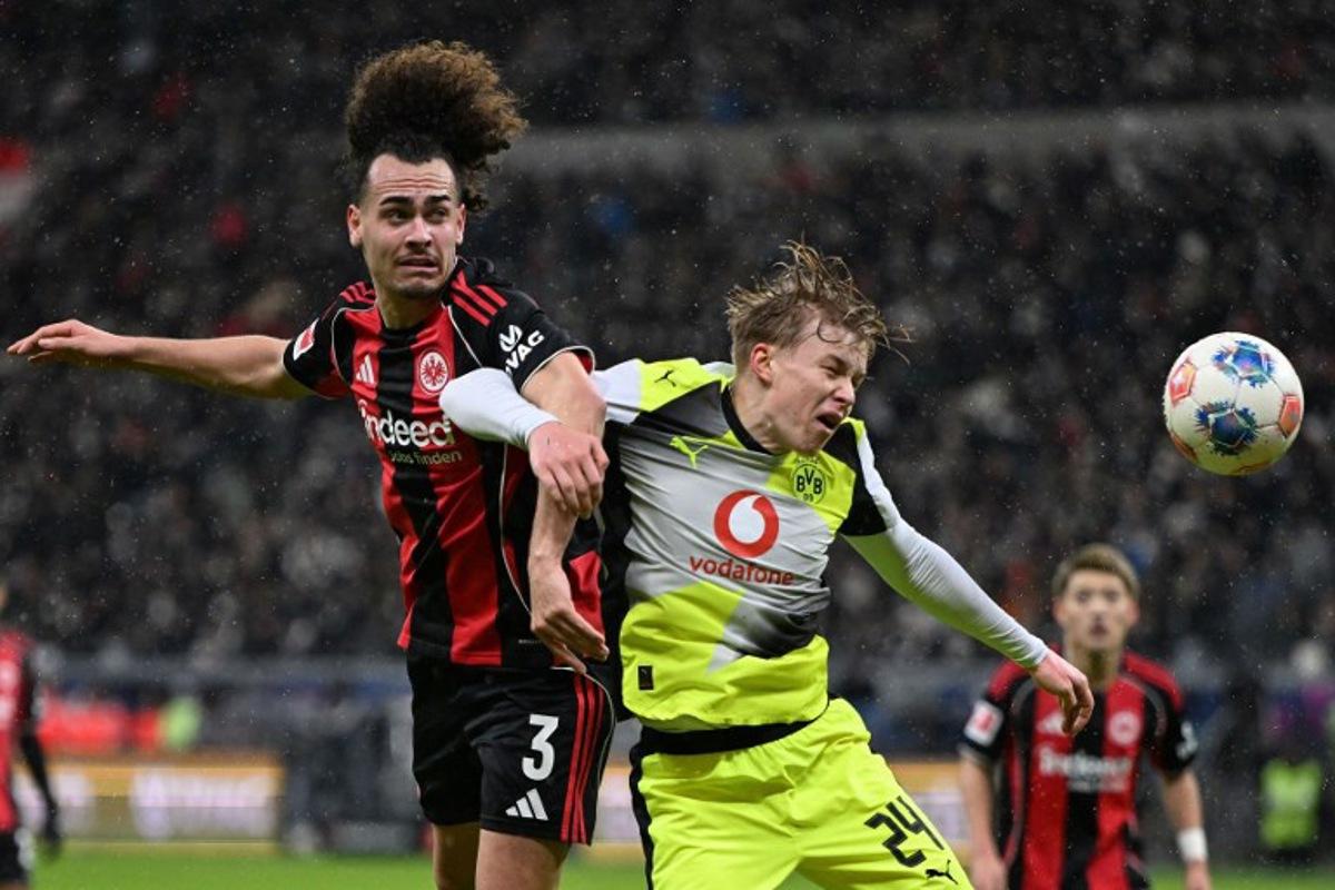 Frankfurt's Belgian defender #03 Arthur Theate (L) and Dortmund's Swedish defender #24 Daniel Svensson vie for the ball during the German first division Bundesliga football match between Eintracht Frankfurt and BVB Borussia Dortmund in Frankfurt am Main, western Germany, on January 9, 2026. Kirill KUDRYAVTSEV / AFP