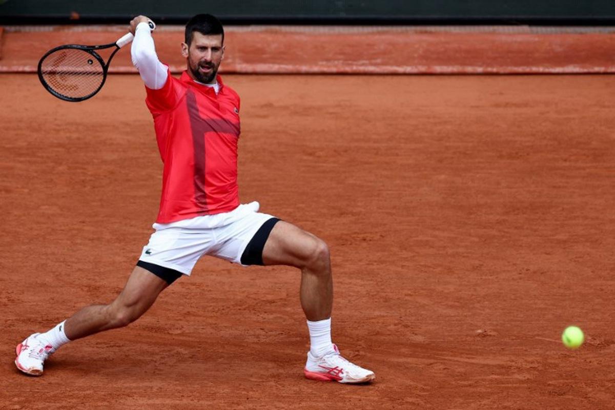 Serbia's Novak Djokovic plays a backhand return to US Mackenzie Mcdonald during their men's singles match on day 3 of the French Open tennis tournament on Court Philippe-Chatrier at the Roland-Garros Complex in Paris on May 27, 2025. FRANCK FIFE / AFP
