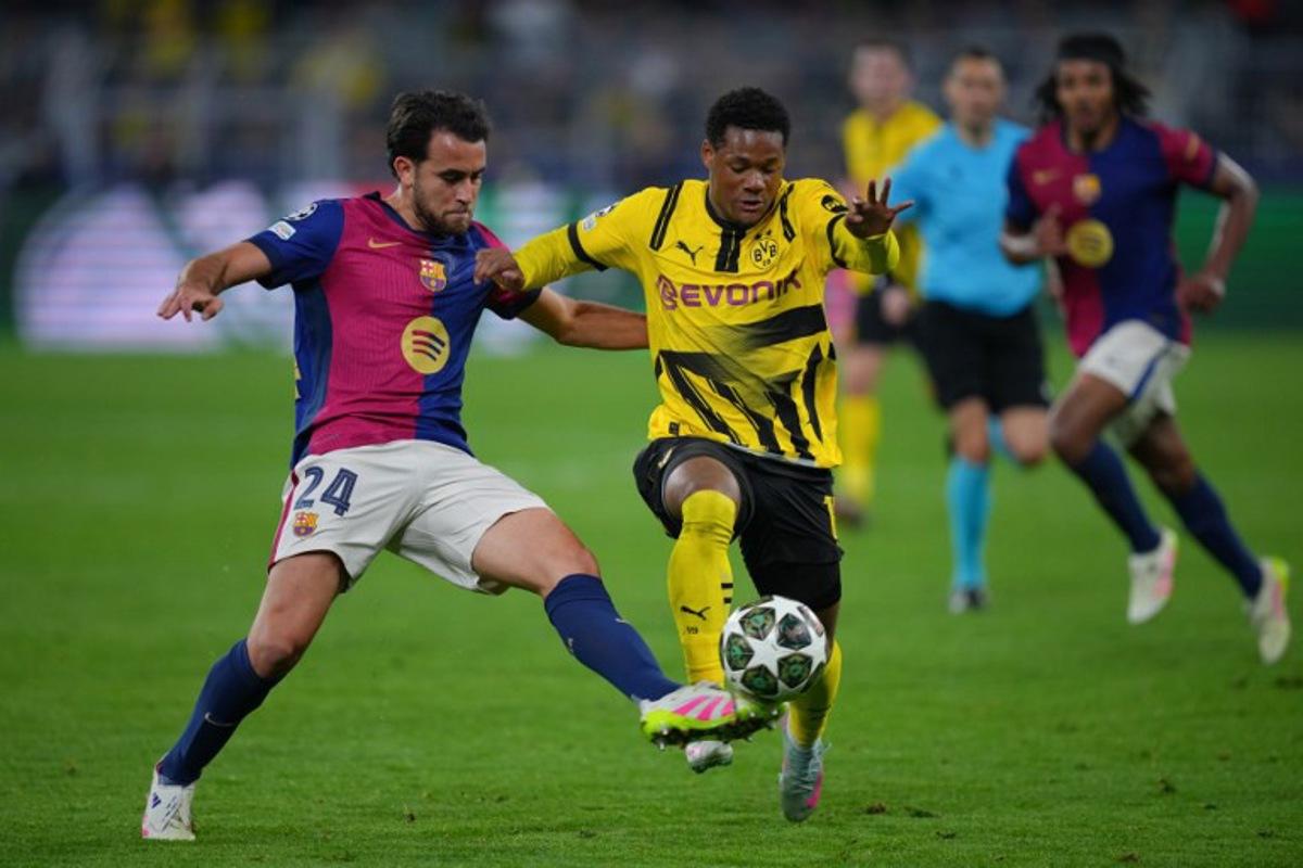Barcelona's Spanish defender #24 Eric Garcia (L)and Dortmund's Belgian forward #16 Julien Duranville vie for the ball during the UEFA Champions League quarter-final second leg football match between BVB Borussia Dortmund and FC Barcelona in Dortmund, western Germany on April 15, 2025. Pau BARRENA / AFP