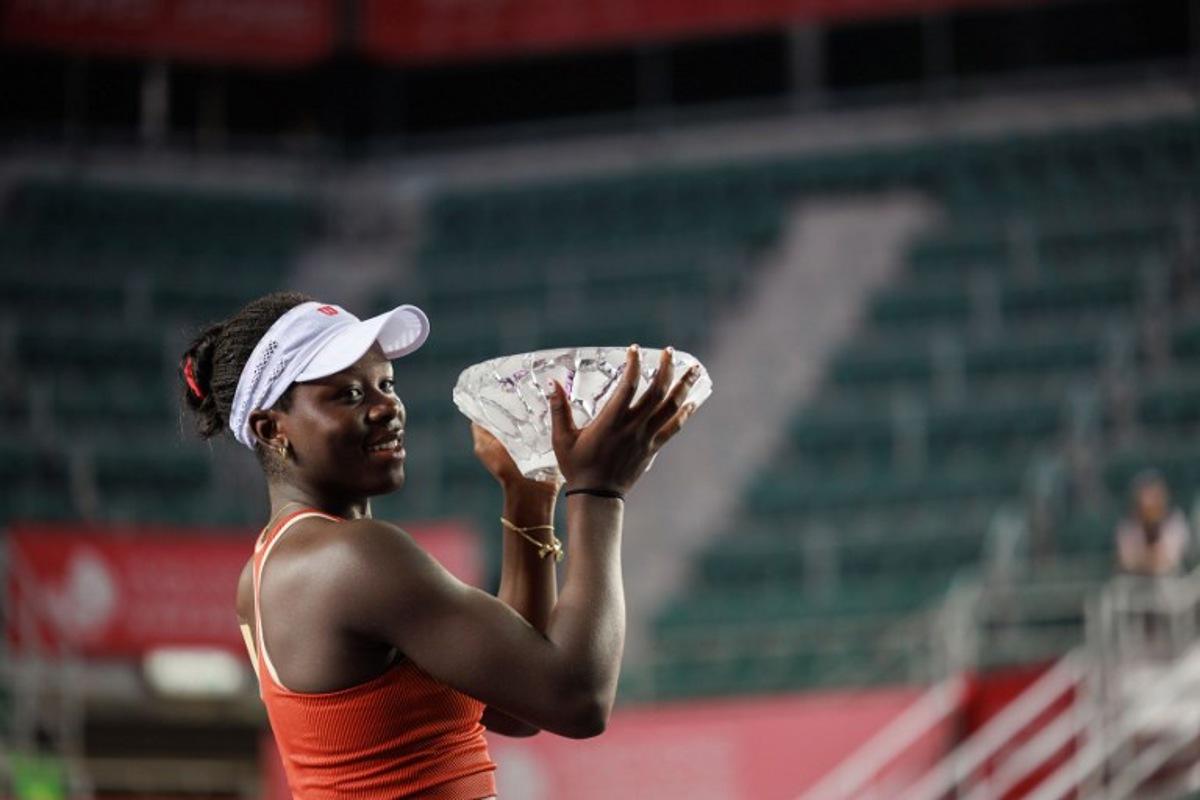Victoria Mboko of Canada holds the trophy after winning against Cristina Bucsa of Spain in the women's singles final of the Hong Kong Tennis Open in Hong Kong on November 2, 2025. May JAMES / AFP