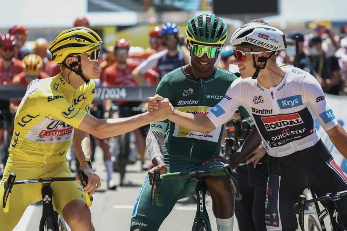UAE Team Emirates team's Slovenian rider Tadej Pogacar wearing the overall leader's yellow jersey shakes hands with Soudal Quick-Step team's Belgian rider Remco Evenepoel wearing the best young rider's white jersey (R) as Intermarche - Wanty team's Eritrean rider Biniam Girmay wearing the sprinter's green jersey (C) looks at the start of the 20th stage of the 111th edition of the Tour de France cycling race, 132,8 km between Nice and Col de la Couillole, southeastern France, on July 20, 2024. Anne-Christine POUJOULAT / AFP
