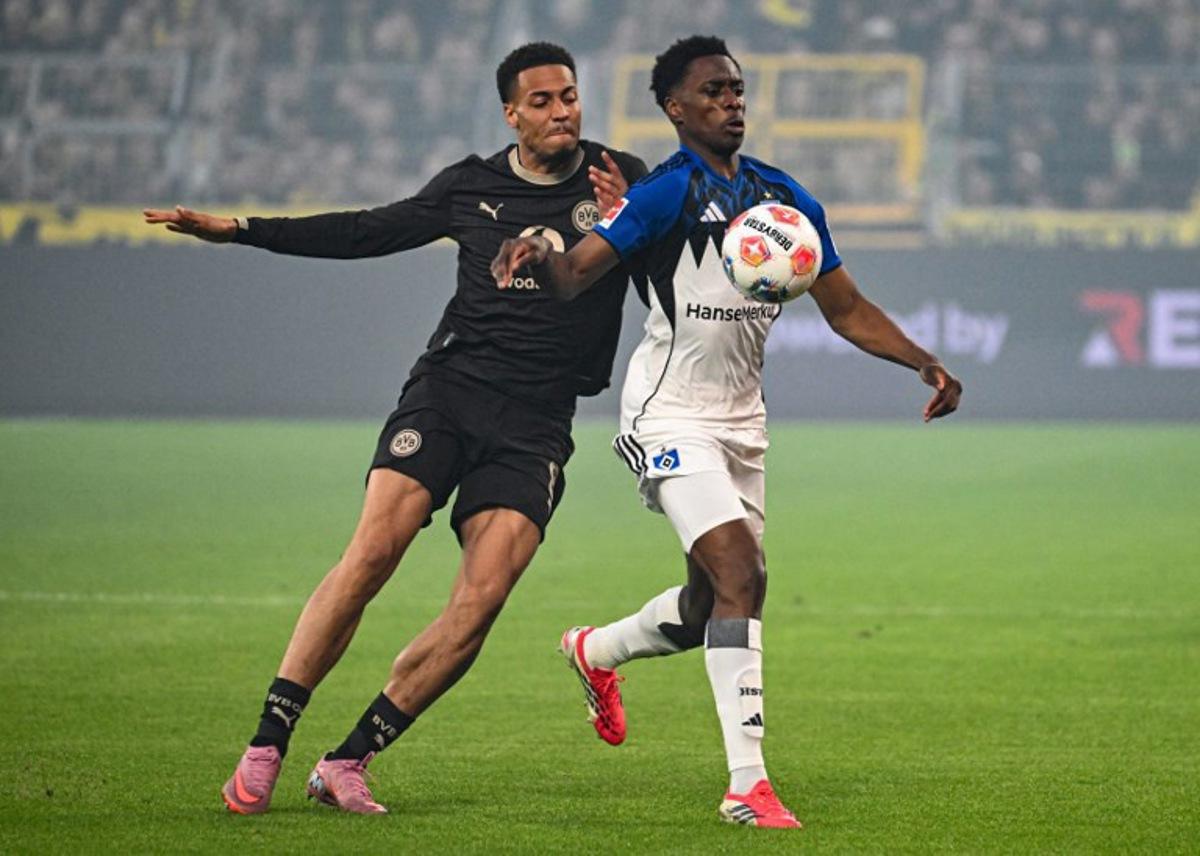 Dortmund's German midfielder #08 Felix Nmecha and Hamburg's Belgian-Congolese midfielder #06 Albert Sambi Lokonga vie for the ball during the German first division Bundesliga football match between Borussia Dortmund and HSV Hamburg in Dortmund, western Germany, on March 21, 2026. UWE KRAFT / AFP