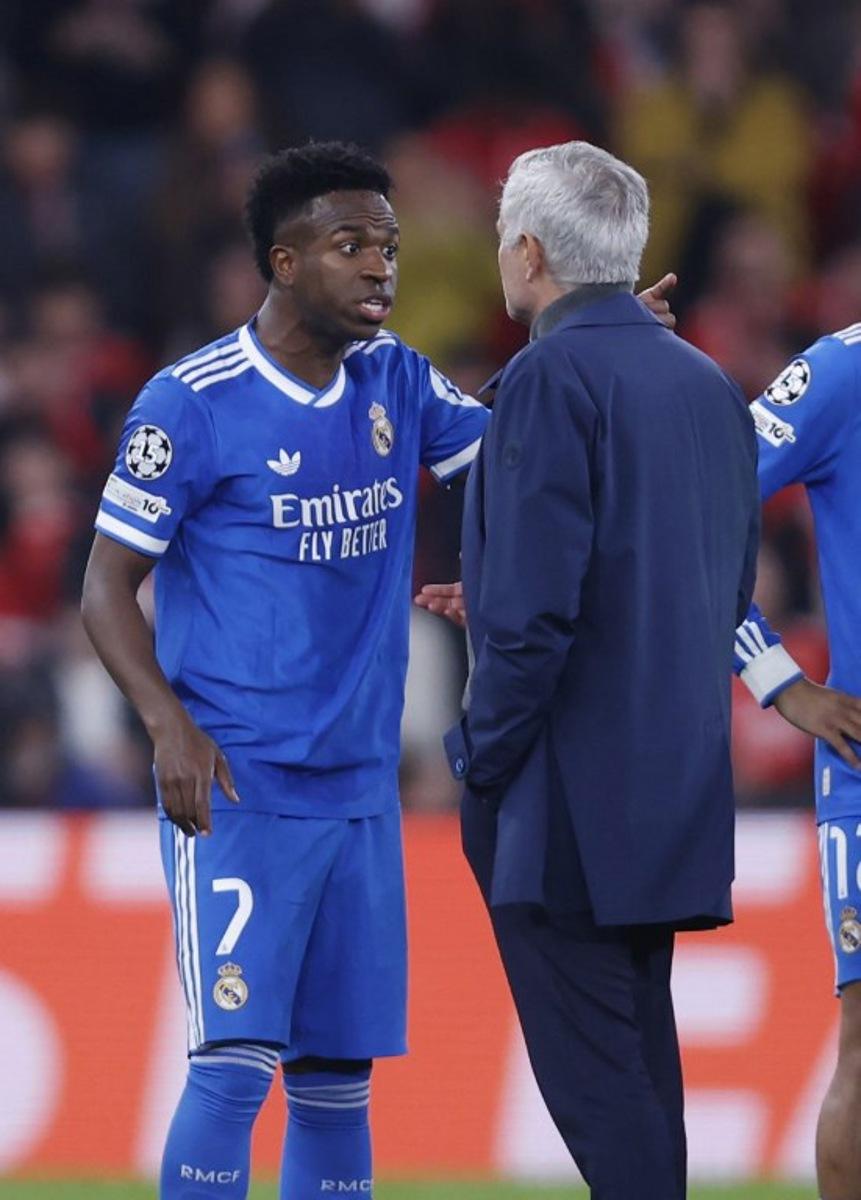 Real Madrid's Brazilian forward #07 Vinicius Junior talks with SL Benfica's Portuguese head coach Jose Mourinho after listening racists insults during the UEFA Champions League knockout round play-off first leg football match between SL Benfica and Real Madrid CF at Estadio da Luz in Lisbon on February 17, 2026. FILIPE AMORIM / AFP