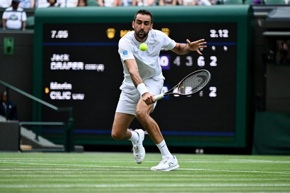 Croatia's Marin Cilic plays a backhand return to Britain's Jack Draper during their men's singles second round tennis match on the fourth day of the 2025 Wimbledon Championships at The All England Lawn Tennis and Croquet Club in Wimbledon, southwest London, on July 3, 2025. Kirill KUDRYAVTSEV / AFP