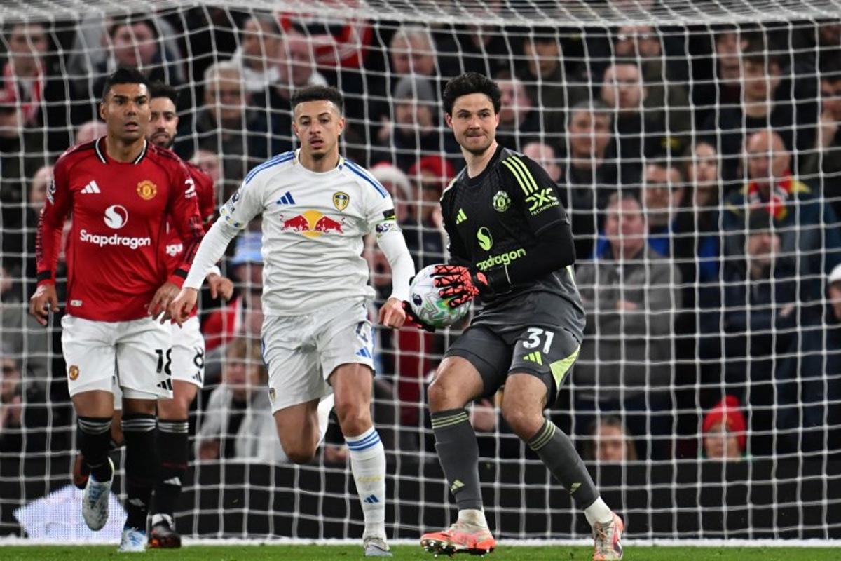Manchester United's Belgian goalkeeper #31 Senne Lammens (R) prepares to throw the ball during the English Premier League football match between Manchester United and Leeds United at Old Trafford in Manchester, north west England, on April 13, 2026. Paul ELLIS / AFP