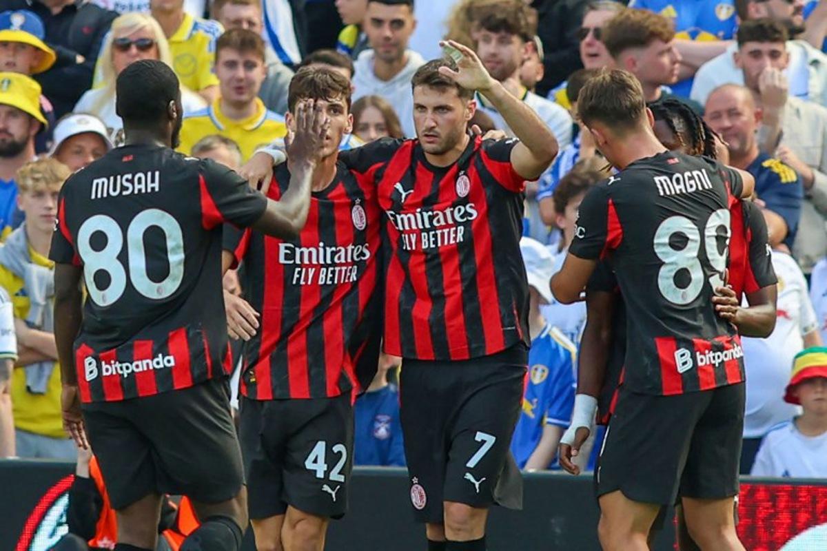 AC Milan's Mexican striker #07 Santiago Gimenez (C) celebrates with teammates after scoring the opening goal during the pre-season friendly football match between Leeds United and AC Milan at the Aviva Stadium in Dublin on August 9, 2025. Paul Faith / AFP