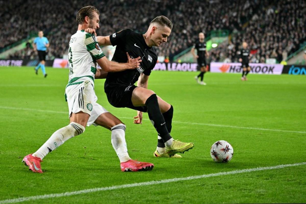 Celtic's Swedish midfielder #08 Benjamin Nygren battles for the ball with Sturm Graz's Belgian defender #24 Dimitri Lavalee during the UEFA Europa League league-stage football match between Celtic and Sturm Graz at Celtic Park in Glasgow on October 23, 2025. ANDY BUCHANAN / AFP