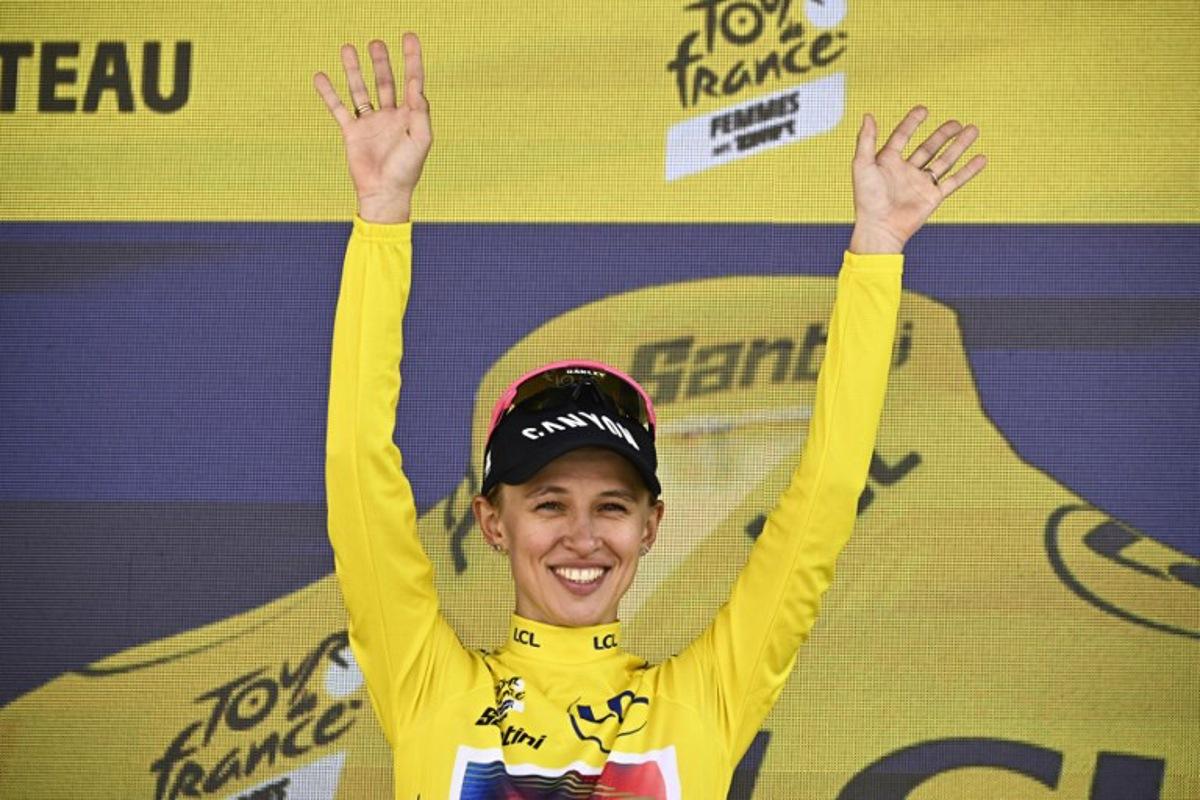 Canyon//SRAM Racing team's Polish rider Katarzyna Niewiadoma celebrates her overall leader's yellow jersey on the podium after the 6th stage (out of 8) of the third edition of the Women's Tour de France cycling race, a 159.2 km between Remiremont and Morteau, eastern France, on August 16, 2024. JULIEN DE ROSA / AFP