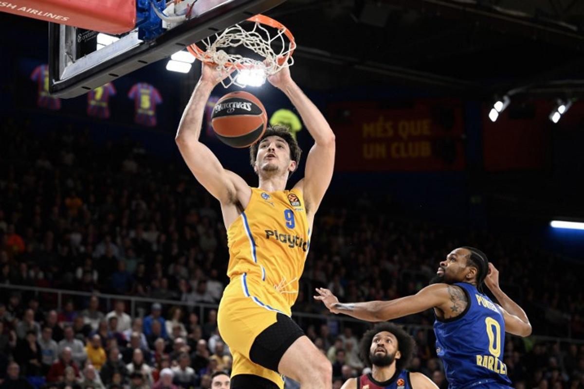 Maccabi's Israeli forward #09 Roman Sorkin (L) dunks the ball as Barcelona's US guard #0 Kevin Punter (R) looks on during the Euroleague basketball match between FC Barcelona and Maccabi Tel-Aviv at the Palau Blaugrana arena in Barcelona on February 5, 2025 Josep LAGO / AFP