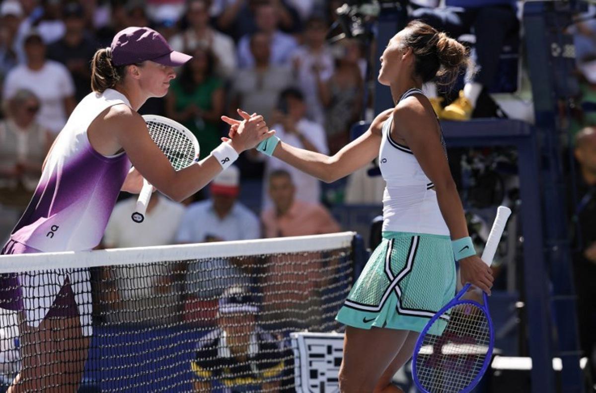 China's Qinwen Zheng (R) shakes hands with Poland's Iga Swiatek after defeating her in their women's singles round of 16 tennis match on day nine of the US Open tennis tournament at the USTA Billie Jean King National Tennis Center in New York on September 7, 2026. KENA BETANCUR / AFP