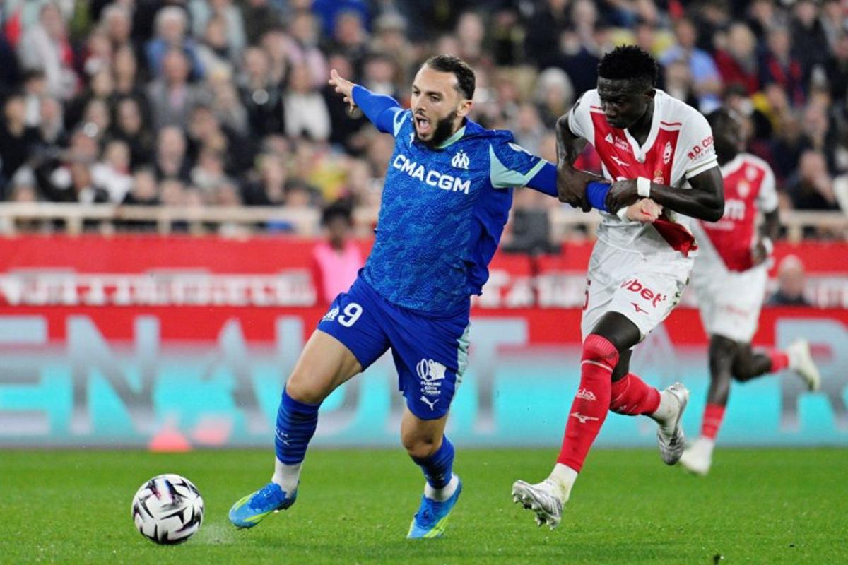 Marseille's Algerian forward #09 Amine Gouiri (L) vies with Monaco's Senegalese midfielder #15 Lamine Camara (R) during the French L1 football match between Monaco (ASM) and Olympique de Marseille (OM) at the Louis II Stadium in Monaco on April 5, 2026. Frederic DIDES / AFP