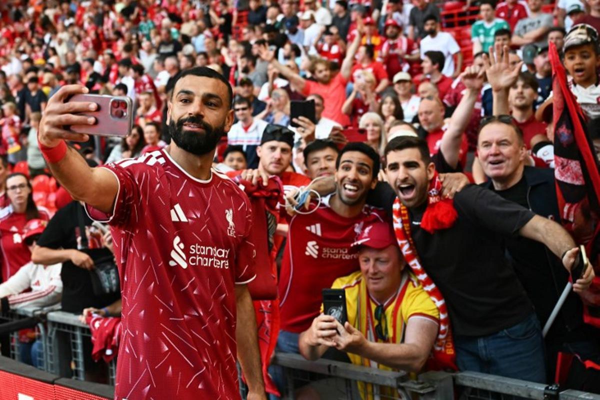 Liverpool's Egyptian striker #11 Mohamed Salah takes a selfie with fans after the English Premier League football match between Liverpool and Brentford at Anfield in Liverpool, north west England on May 24, 2026. Paul ELLIS / AFP