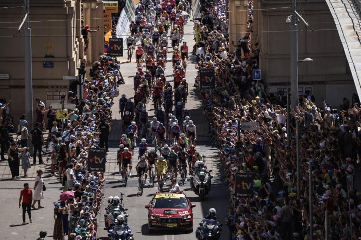 The pack of riders (peloton) cycles in Montpellier at the start of the 16th stage of the 112th edition of the Tour de France cycling race, 171.5 km between Montpellier and Mont Ventoux, southern France, on July 22, 2025. Anne-Christine POUJOULAT / AFP