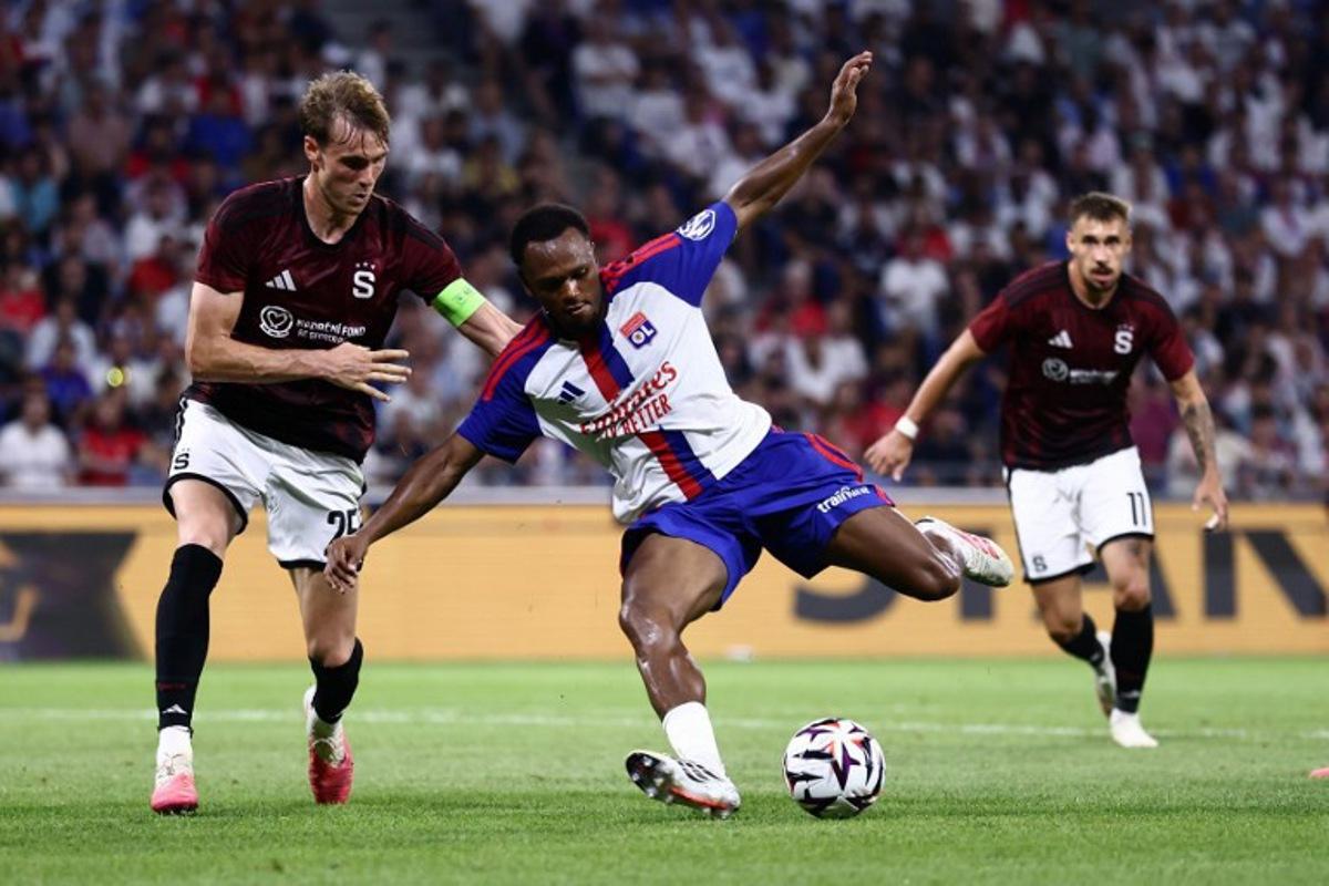Sparta Praha's Danish defender #25 Asger Sorensen (L) and Lyon's Belgian forward #17 Lois Openda (C) fight for the ball during the UEFA Champions League third qualifying round - second leg football match between Olympique Lyonnais (OL) and Sparta Prague at Groupama Stadium in Decines-Charpieu, central-eastern France on August 11, 2026. Alex MARTIN / AFP