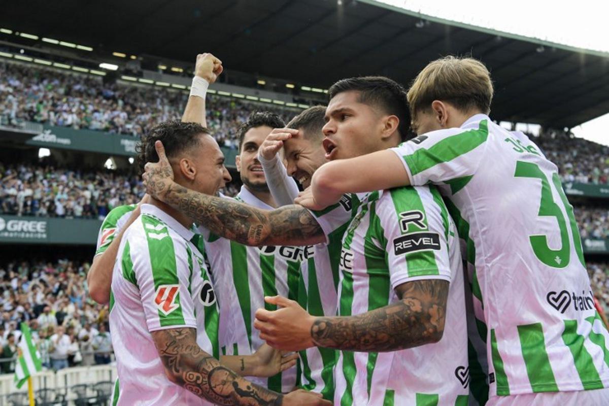 Real Betis' players celebrate after scoring their first goal during the Spanish league football match between Real Betis and Villarreal CF at the Benito Villamarin stadium in Seville on April 13, 2025. CRISTINA QUICLER / AFP