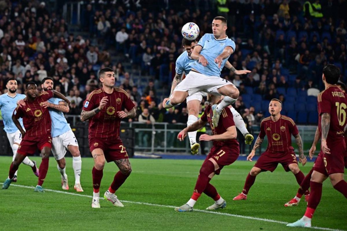 Lazio's Montenegrin defender #77 Adam Marusic jumps for the ball during the Italian Serie A football match between Lazio and Roma at the Olympic Stadium in Rome on April 13, 2025. Tiziana FABI / AFP