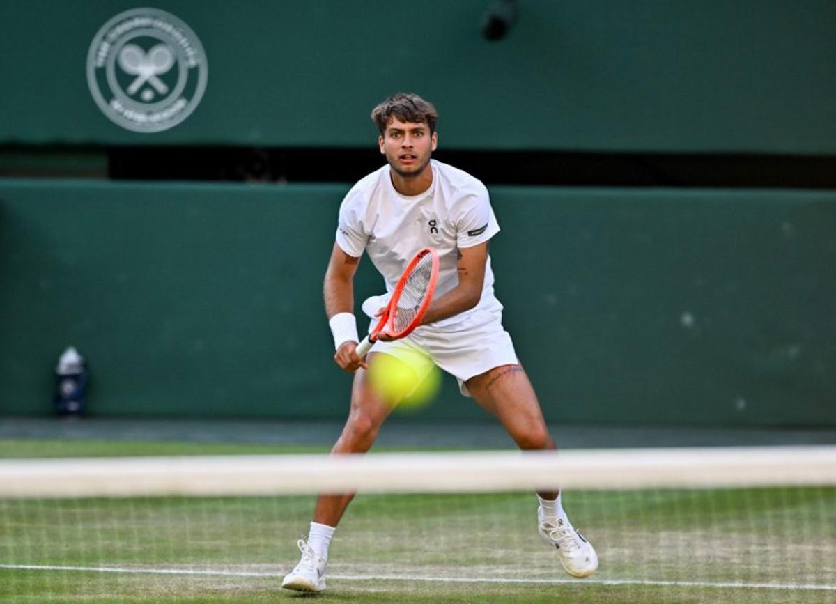 Italy's Flavio Cobolli returns the ball to Serbia's Novak Djokovic during their men's singles quarter-final tennis match on the tenth day of the 2025 Wimbledon Championships at The All England Lawn Tennis and Croquet Club in Wimbledon, southwest London, on July 9, 2025. Glyn KIRK / AFP
