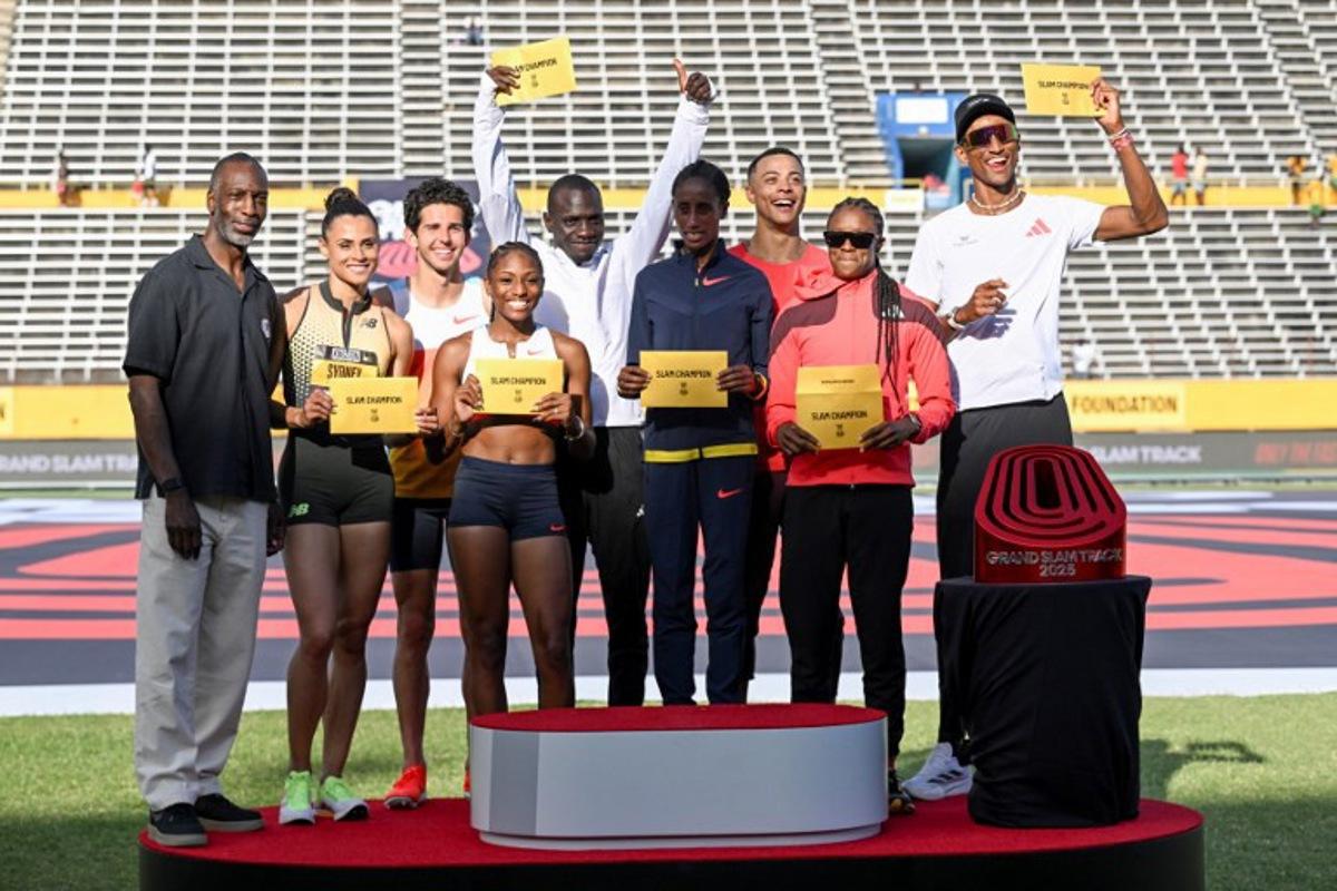 (L/R) Retired US Olympic and World Champion sprinter Michael Johnson poses alongside Grand Slam Champions USA's Sydney Mclaughlin-Levrone, USA's Grant Fisher, USA's Melissa Jefferson, Kenya's Emmanuel Wanyonyi, Ethiopia's Ejgayehu Taye, France's Sasha Zhoya, Jamaica's Danielle Williams and Brazil's Alison Dos Santos pose on the podium on the final day of the Grand Slam Track competition at the National Stadium in Kingston, Jamaica, on April 6, 2025. Ricardo Makyn / AFP