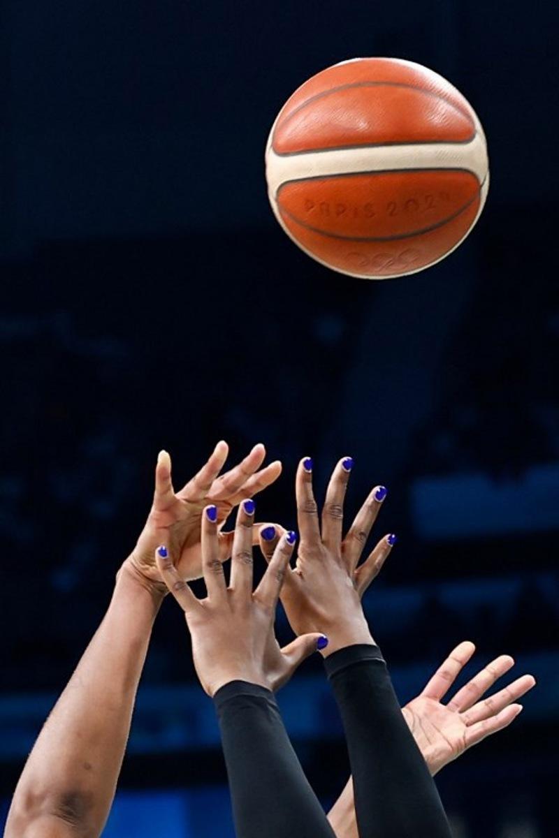 France's #22 Marieme Badiane (L) and Nigeria's #0 Amy Okonkwo go for a rebound in the women's preliminary round group B basketball match between France and Nigeria during the Paris 2024 Olympic Games at the Pierre-Mauroy stadium in Villeneuve-d'Ascq, northern France, on August 1, 2024. Sameer Al-Doumy / AFP
