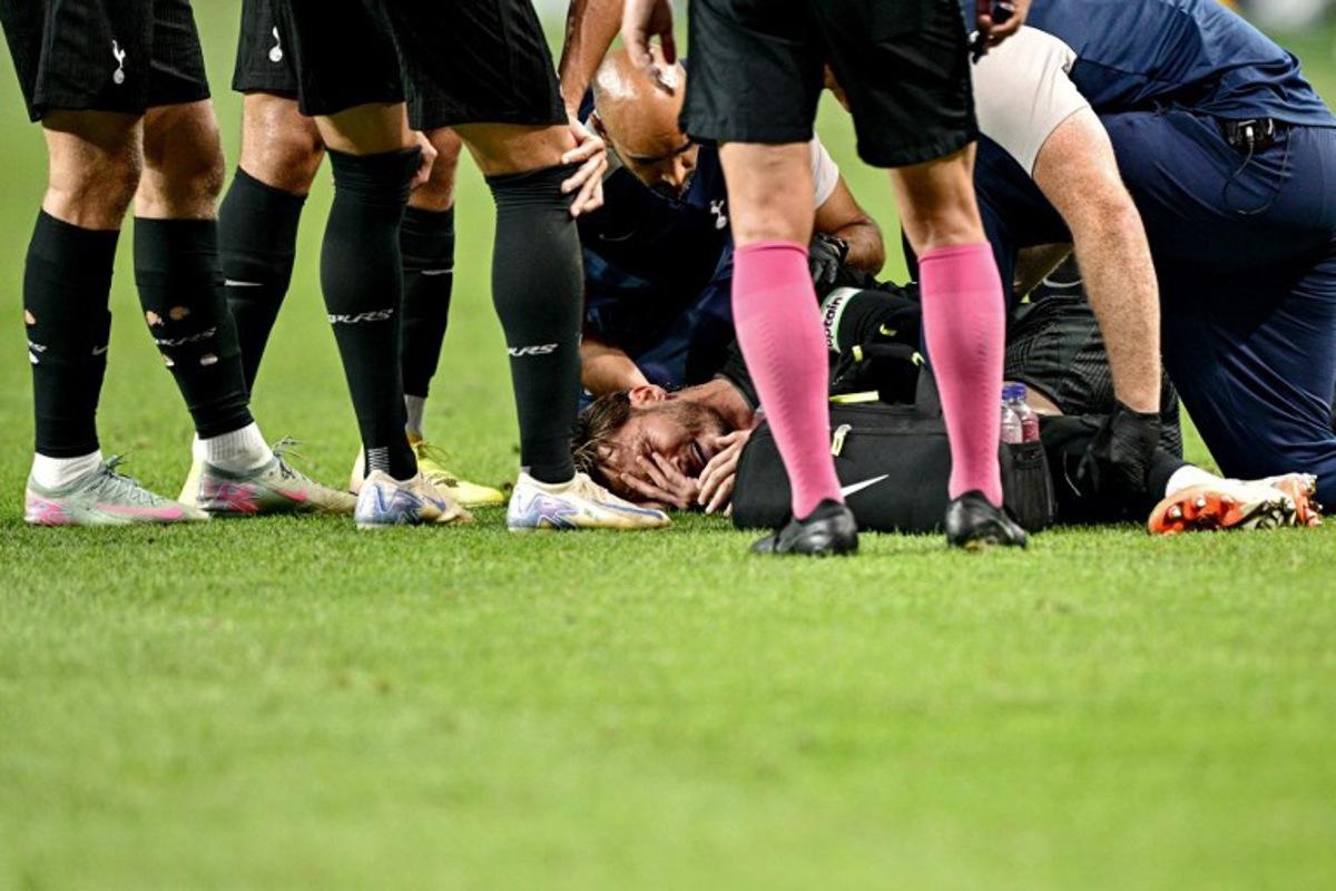 Tottenham Hotspur's James Maddison (C) reacts before being stretchered off the pitch, after suffering an injury during a friendly football match between Tottenham Hotspur and Newcastle United in Seoul on August 3, 2025. Anthony WALLACE / AFP