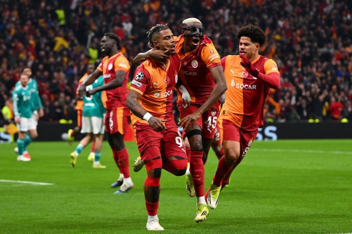 Galatasaray's Gabonese midfielder #99 Mario Lemina (L) celebrates with teammates after scoring the opening goal during the UEFA Champions League round of 16 first leg football match between Galatasaray SK and Liverpool FC at the Ali Sami Yen Sports Complex in Istanbul on March 10, 2026. YASIN AKGUL / AFP