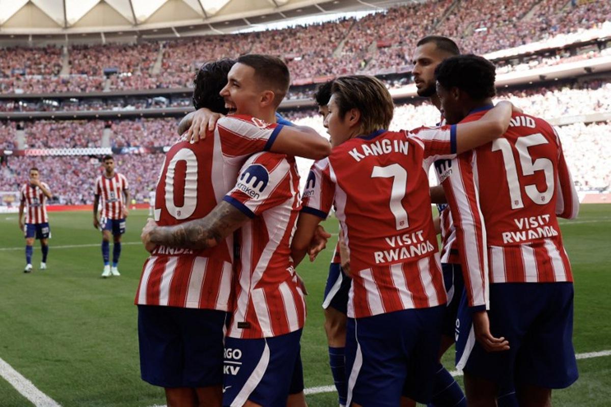 Atletico Madrid's Spanish defender #22 Alejandro Grimaldo (2L) celebrates scoring his team's first goal during the Spanish league football match between Club Atletico de Madrid and Real Madrid CF at the Metropolitano stadium in Madrid on September 20, 2026. Oscar DEL POZO / AFP
