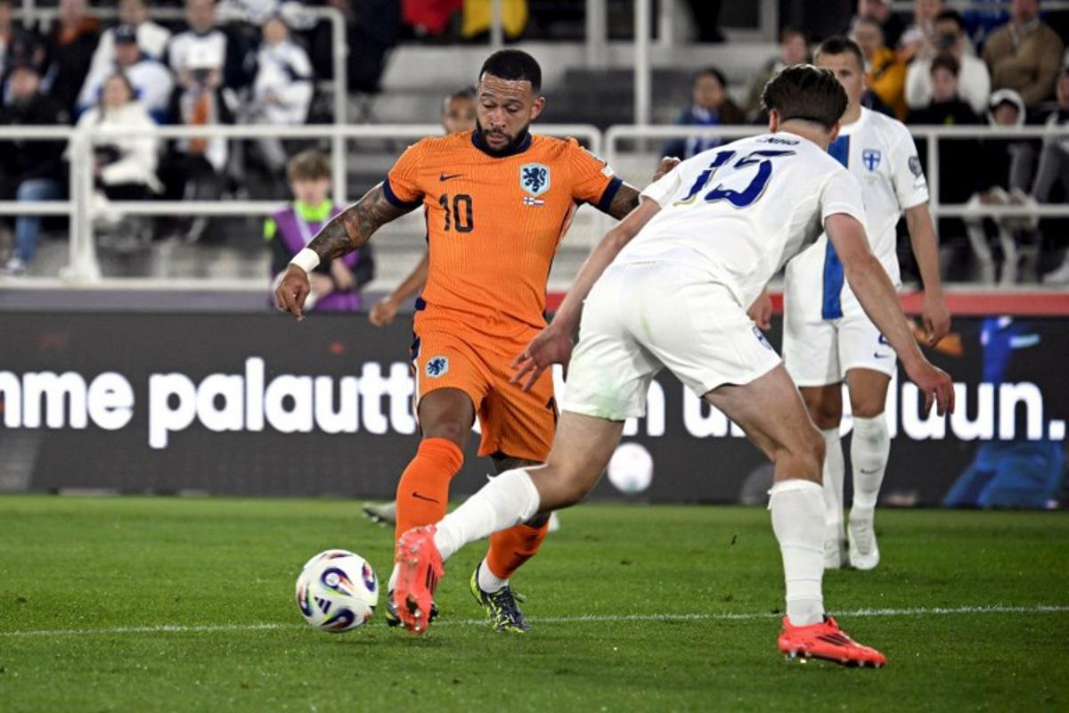 Netherlands' forward #10 Memphis Depay (L) attempts to get past Finland's defender #15 Miro Tenho during the 2026 FIFA World Cup Qualifying Group G football match between Finland and the Netherlands in Helsinki on June 7, 2025. Markku Ulander / LEHTIKUVA / AFP