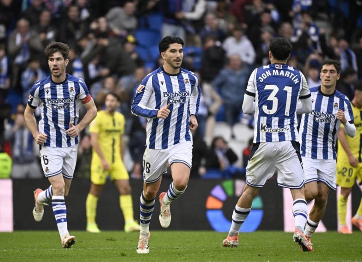 Real Sociedad's Spanish defender #18 Carlos Soler (C) celebrates scoring his team's first goal during the Spanish league football match between Real Sociedad and Villarreal CF at Anoeta Stadium in San Sebastian on November 30, 2025. ANDER GILLENEA / AFP