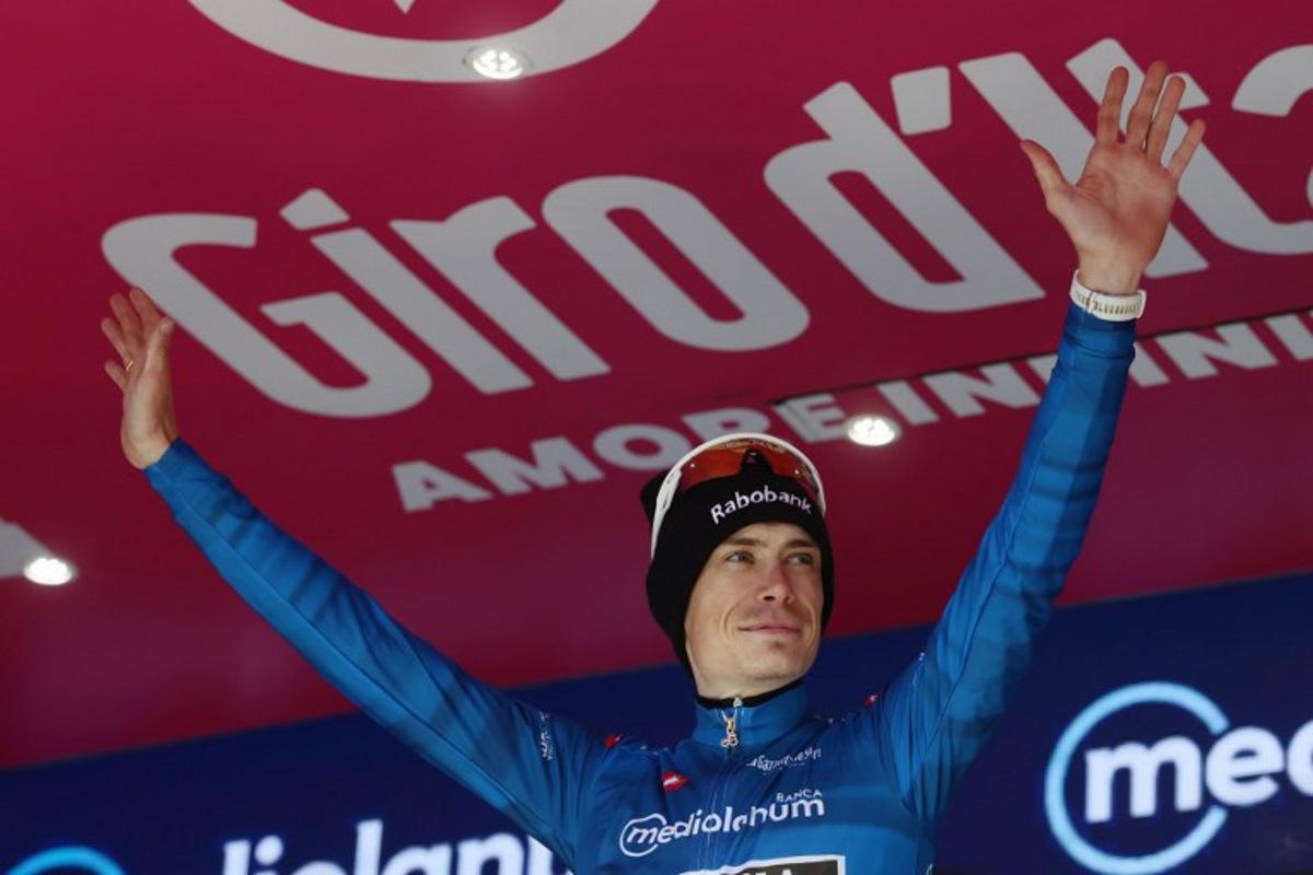 Team Visma Lease a Bike Danish rider Jonas Vingegaard, wearing the best climber's blue jersey (Maglia Azzura), celebrates on the podium for the 8th stage of the Giro d'Italia 2026 - Tour of Italy cycling race between Chieti and Fermo, central Italy on May 16, 2026. Luca Bettini / AFP
