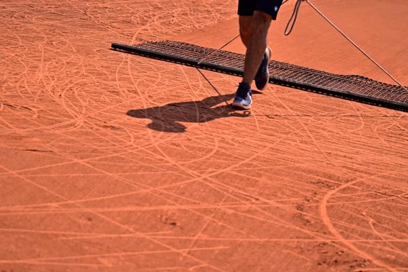 An employee brushes the clay during a wheelchair singles match on day ten of the Roland-Garros Open tennis tournament in Paris on June 6, 2023. JULIEN DE ROSA / AFP