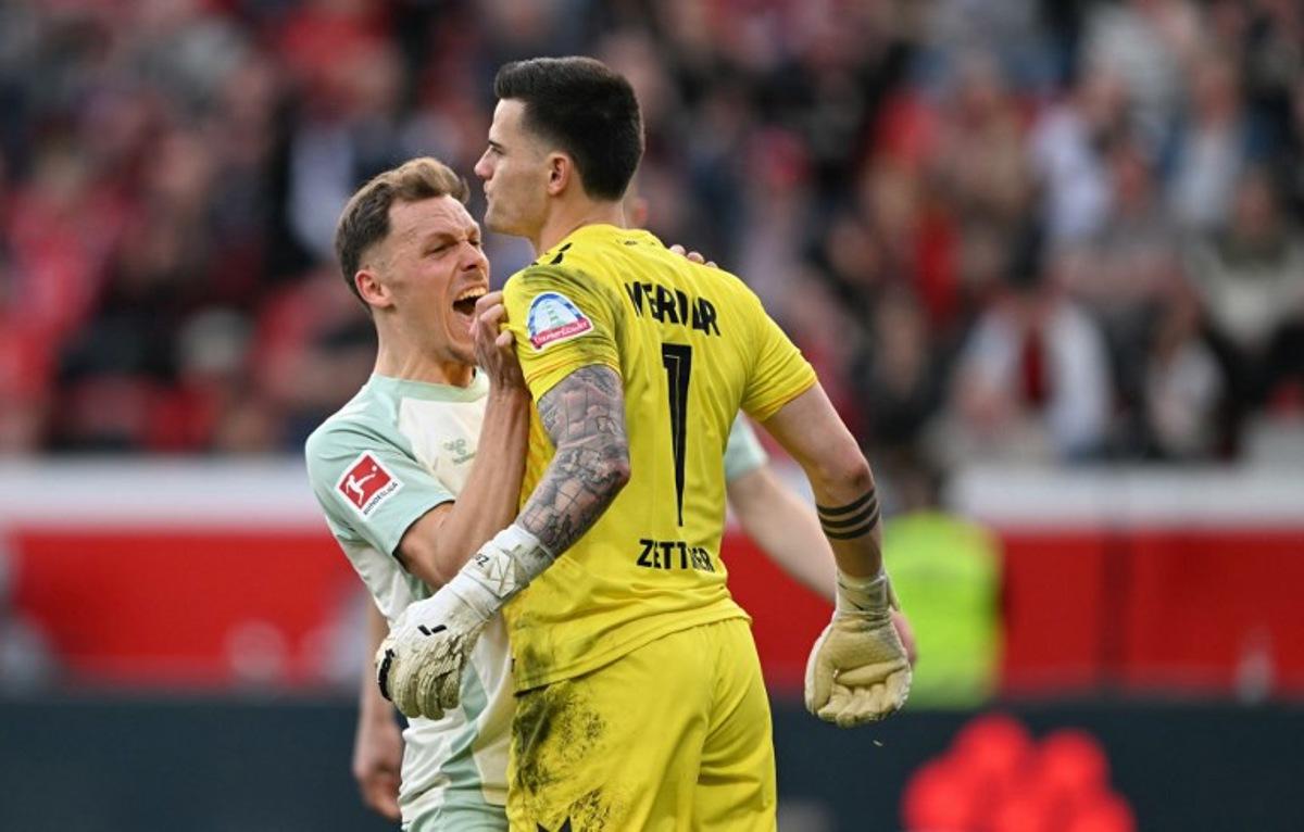 Bremen's Belgian midfielder #14 Senne Lynen (L) and Bremen's German goalkeeper #01 Michael Zetterer react during the German first division Bundesliga football match between Bayer Leverkusen and Werder Bremen in Leverkusen, western Germany, on March 8, 2025. INA FASSBENDER / AFP