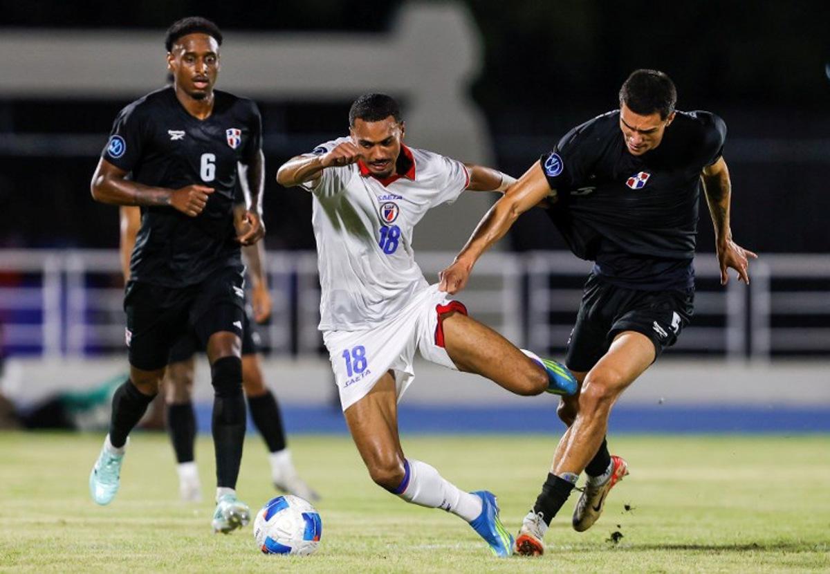 Haiti's forward #18 Wilson Isidor and Dominican Republic's defender #05 Noah Dollenmayer fight for the ball during the Concacaf Nations League Cup football match between Dominican Republic and Haiti at the Felix Sanchez Olympic Stadium in Santo Domingo on October 1, 2026. Nelson PULIDO / AFP