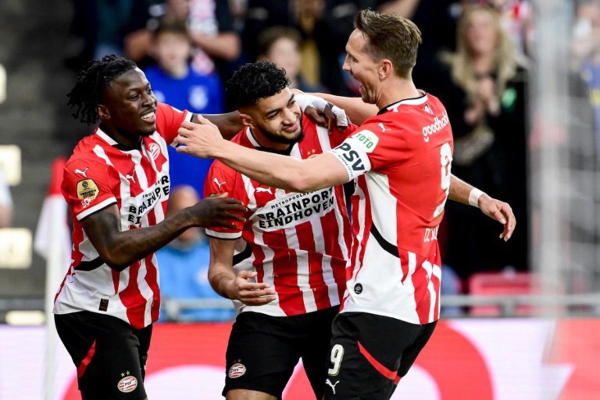 PSV's Moroccan midfielder #34 Ismael Saibari (C) celebrates with PSV's Dutch forward #09 Luuk de Jong (R) and PSV's Belgium forward #11 Johan Bakayoko (L) after scoring PSV's first goal during the Dutch Eredivisie fooball match between PSV Eindhoven and Almere City FC at the Phillips Stadium in Eindhoven on April 12, 2025. Olaf Kraak / ANP / AFP