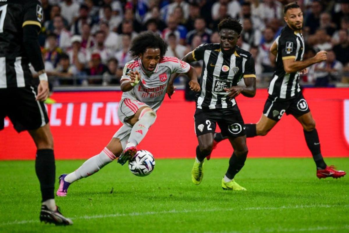 Lyon's Belgian forward #11 Malick Fofana (C-L) fights for the ball with Angers' Haitian defender #02 Carlens Arcus (C-R) during the French L1 football match between Olympique Lyonnais (OL) and SCO Angers at the Groupama Stadium in Decines-Charpieu, near Lyon, central-eastern France on September 19, 2025. OLIVIER CHASSIGNOLE / AFP